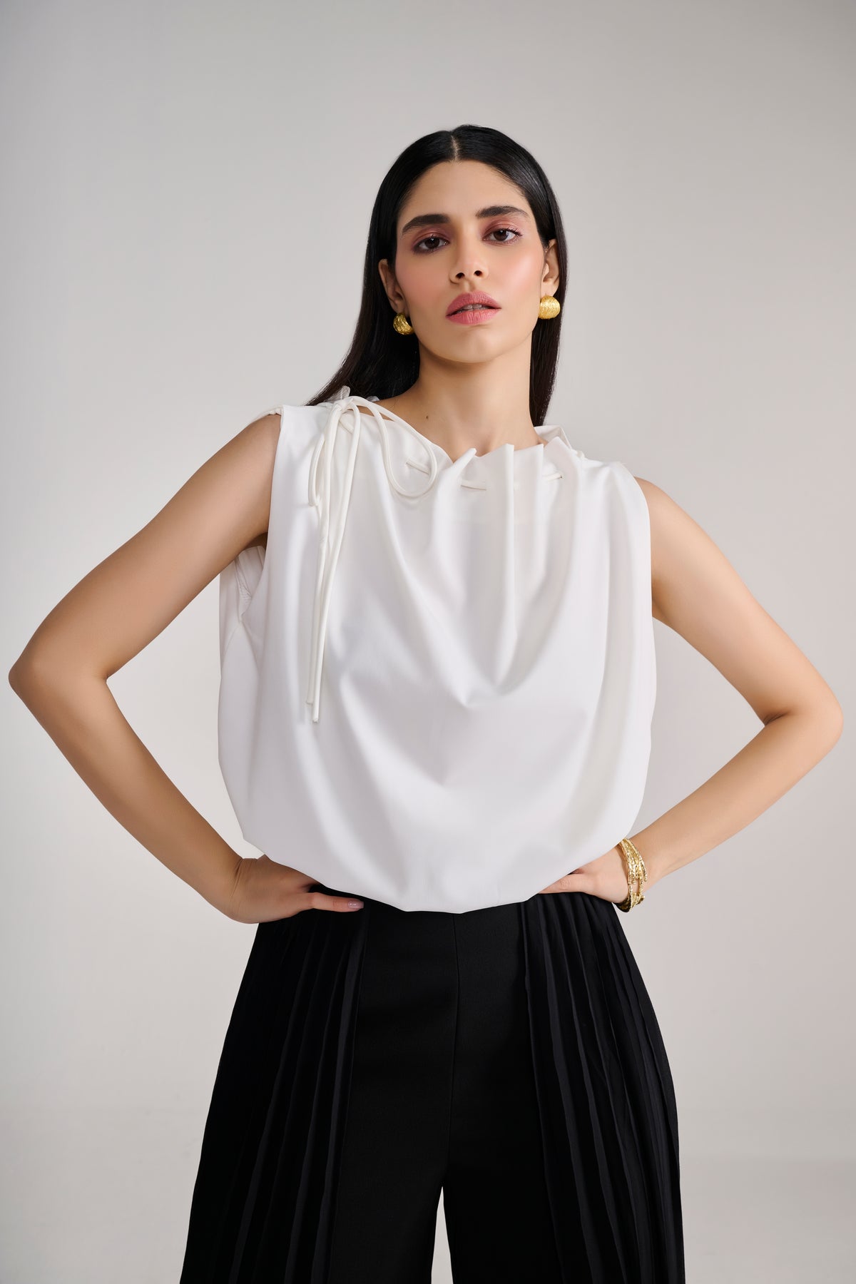 White sleeveless balloon top with tie up detail at neck