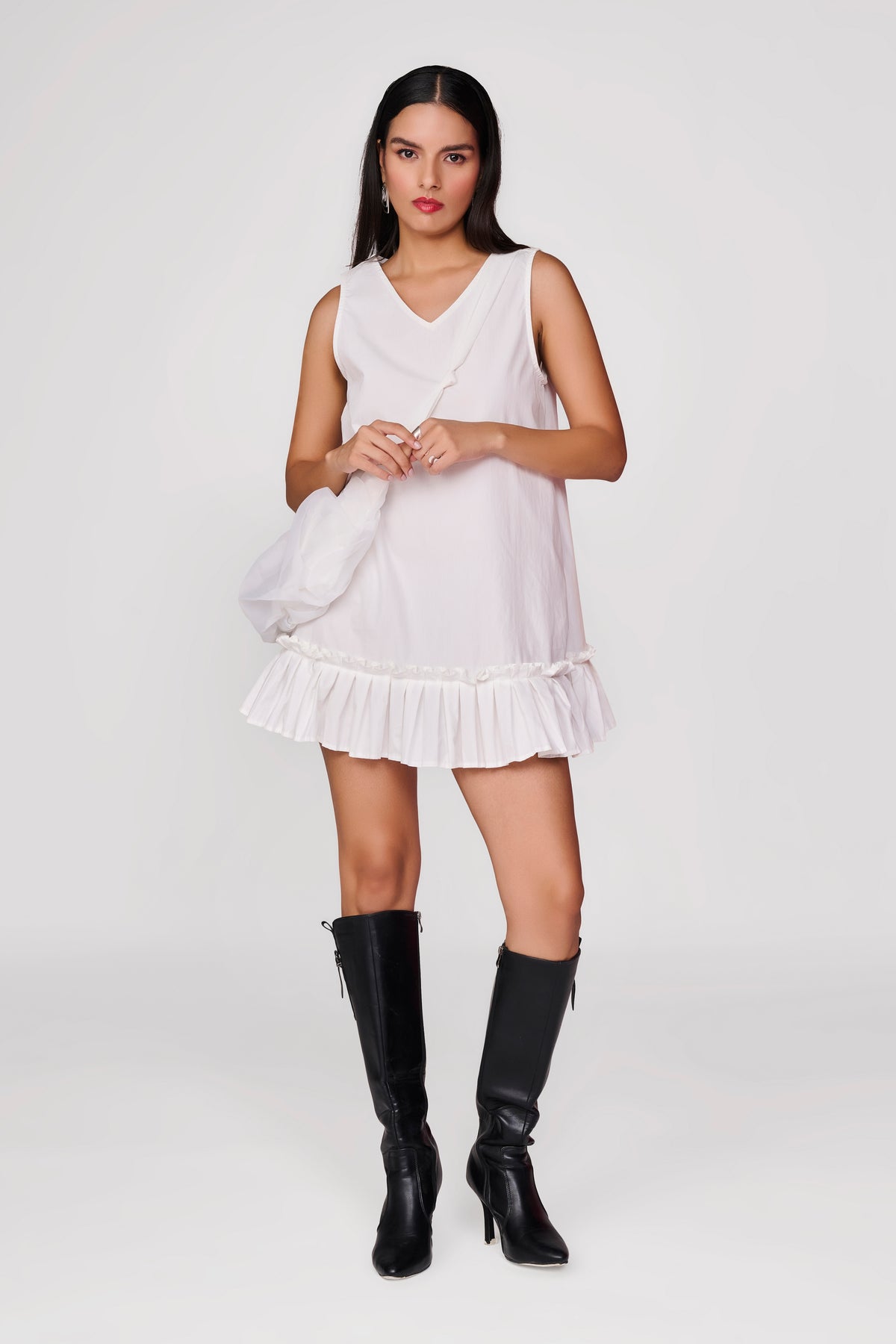 Short white dress with pleated detail at hem and sling bag